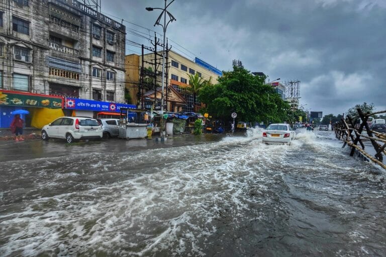 A busy urban street in Kolkata flooded after heavy monsoon rains, showcasing urban infrastructure challenges.