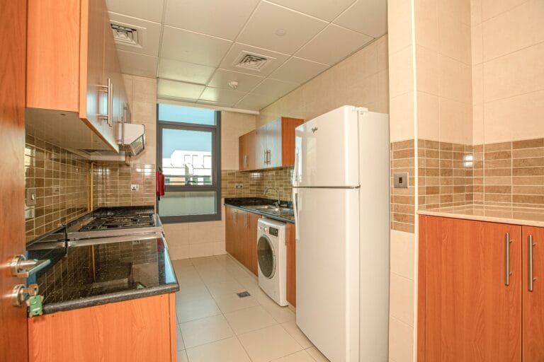Spacious kitchen featuring modern appliances and stylish wooden cabinets, ideal for contemporary living.