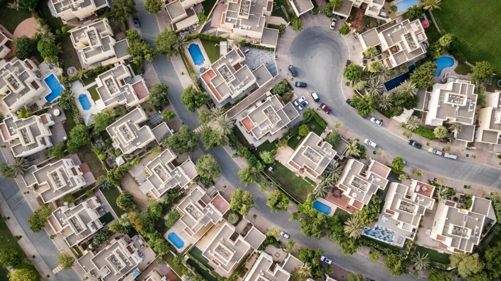 Explore a stunning aerial view of a residential area in Dubai with lush greenery and swimming pools.