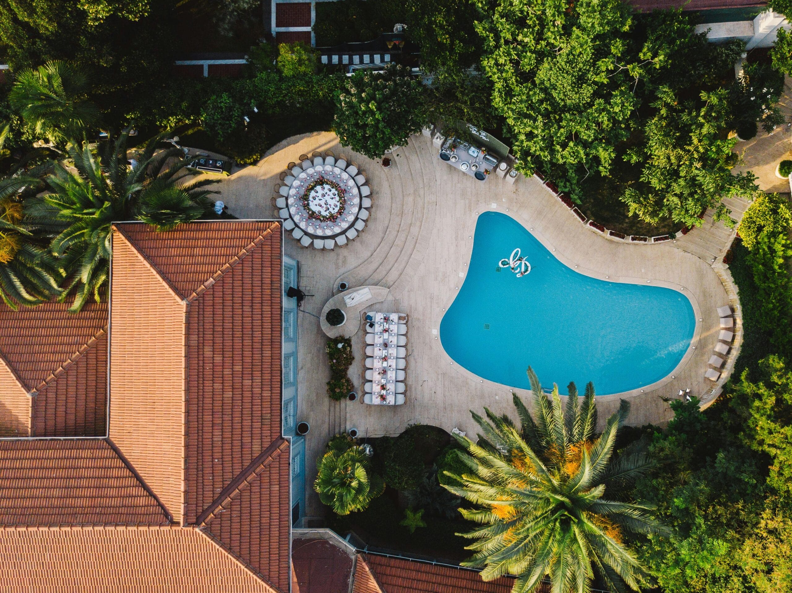 How to Use Water Features to Complement Pool Landscaping A stunning birds-eye view of a tropical resort featuring a swimming pool and lush greenery.