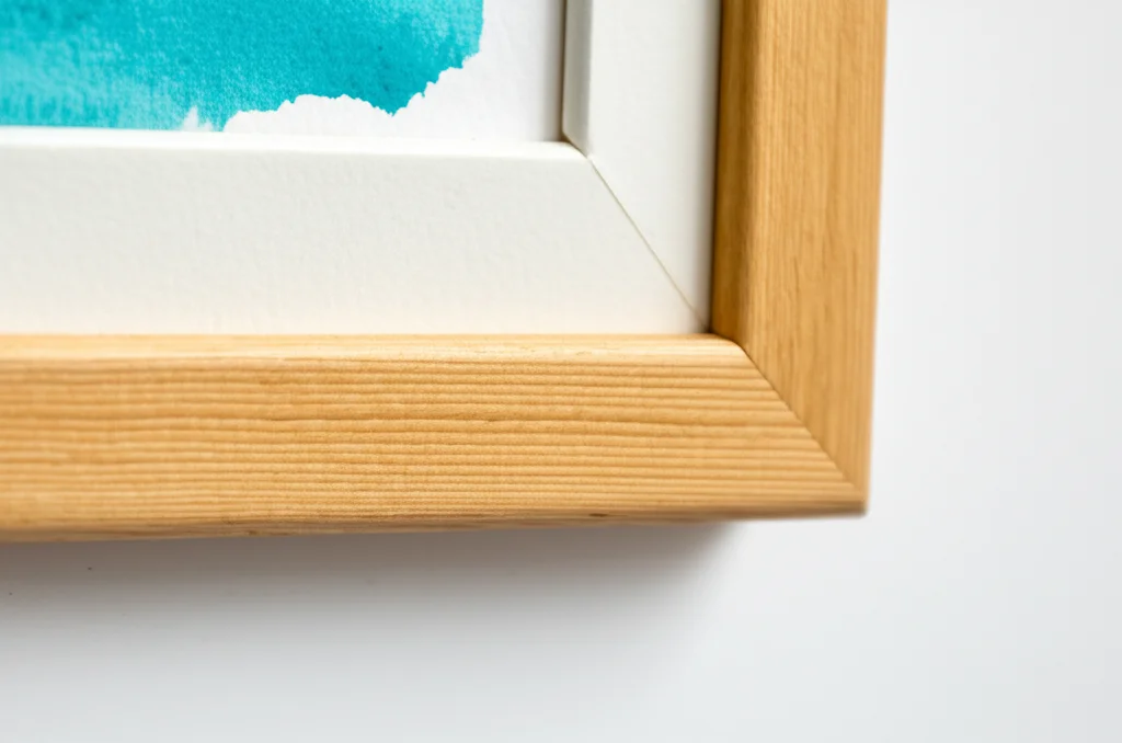 Photorealistic close-up of an 11x17 inch vibrant watercolor painting beautifully framed in a handcrafted wooden frame. S