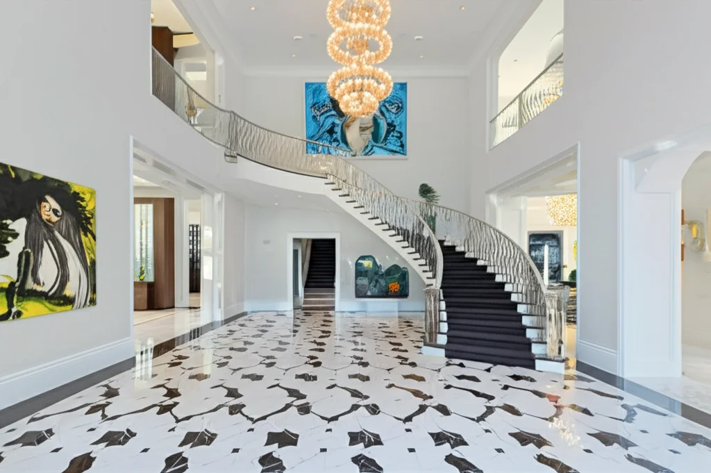 Photorealistic, wide-angle interior shot of Kris Jenner's grand foyer in Hidden Hills, featuring a black and white marbl