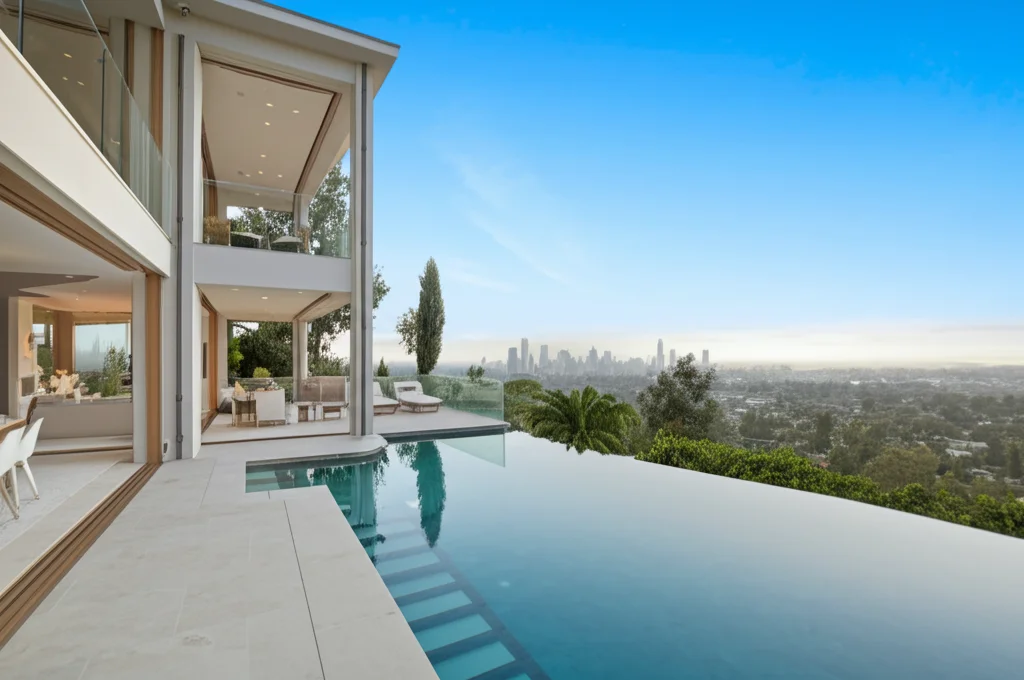 Luxurious, sun-drenched panoramic shot of Sharon Stone's Hollywood Hills mansion exterior, infinity pool reflecting the