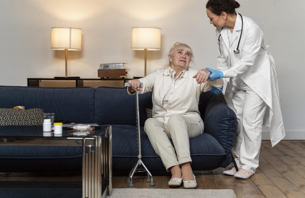 Medical assistant holding tablet with x ray scan for checkup with disabled man in nursing home. Nurse explaining radiography on digital device to senior patient sitting in wheelchair