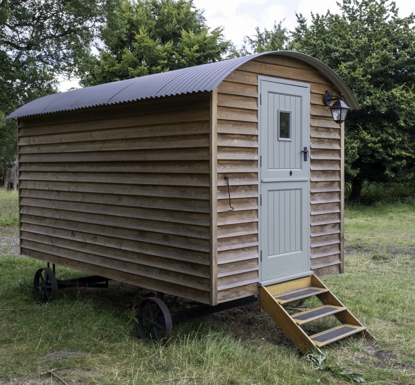 A closeup shot of a small wooden house on wheels